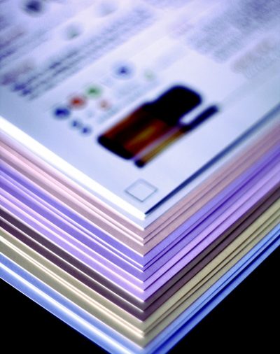 different colored sheets of paper stacked up and fanned out to show each of the colors top page has faded image of essential oils bottle and lettering